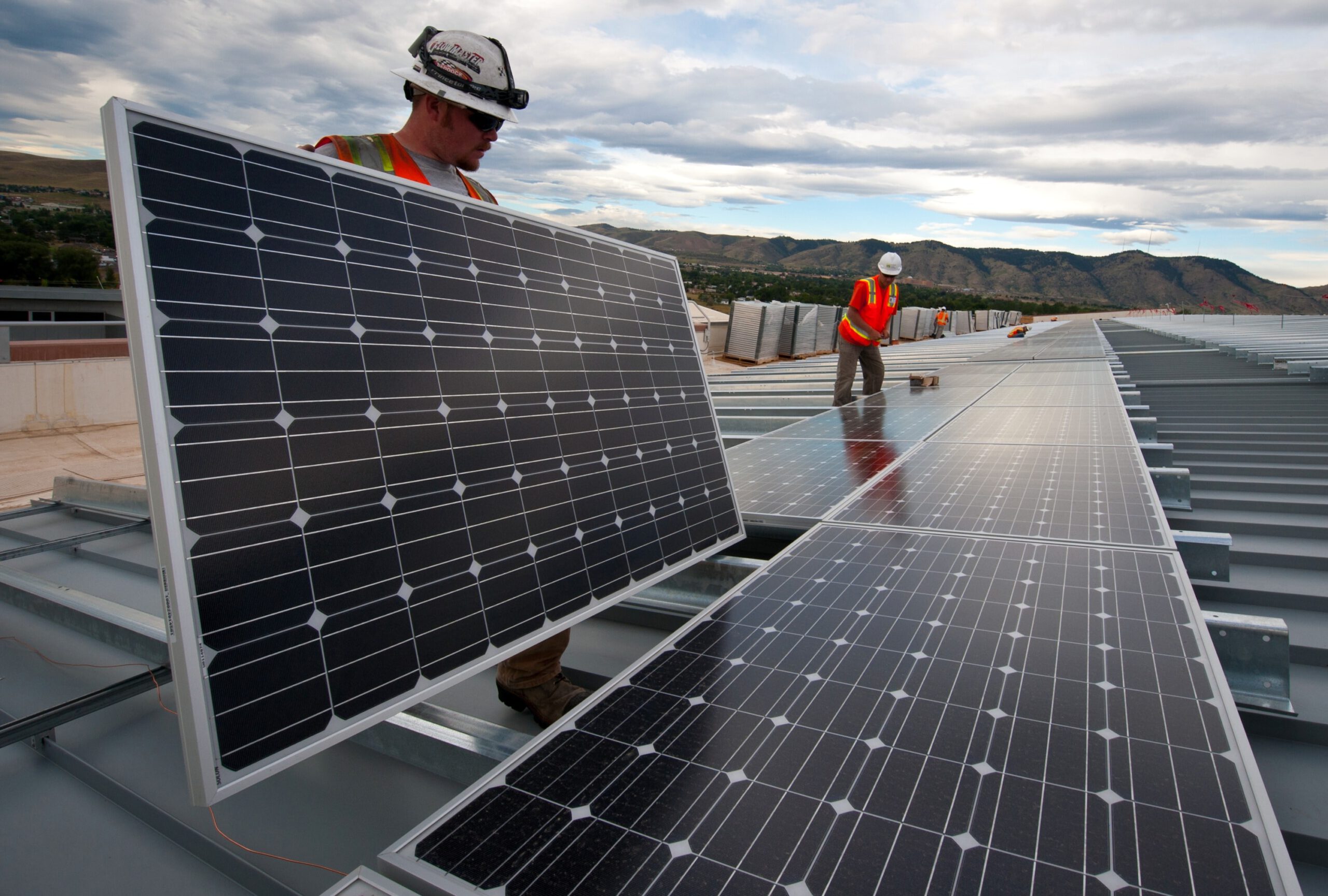 Arbeiter montieren Solaranlage auf dem Dach